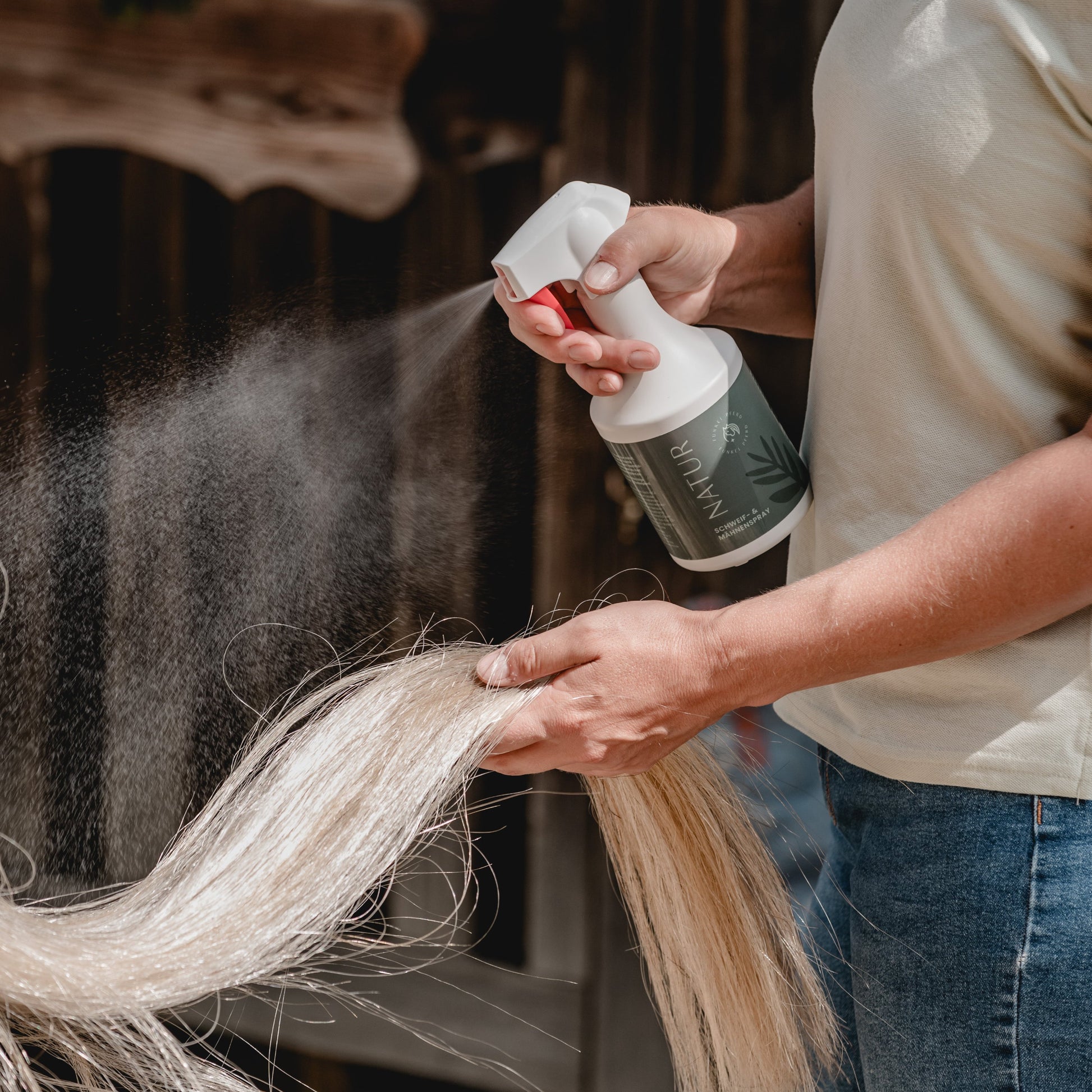 Anwendung des Schweif- und Mähnensprays Natur an einem hellen Schweif mit feinem Sprühnebel